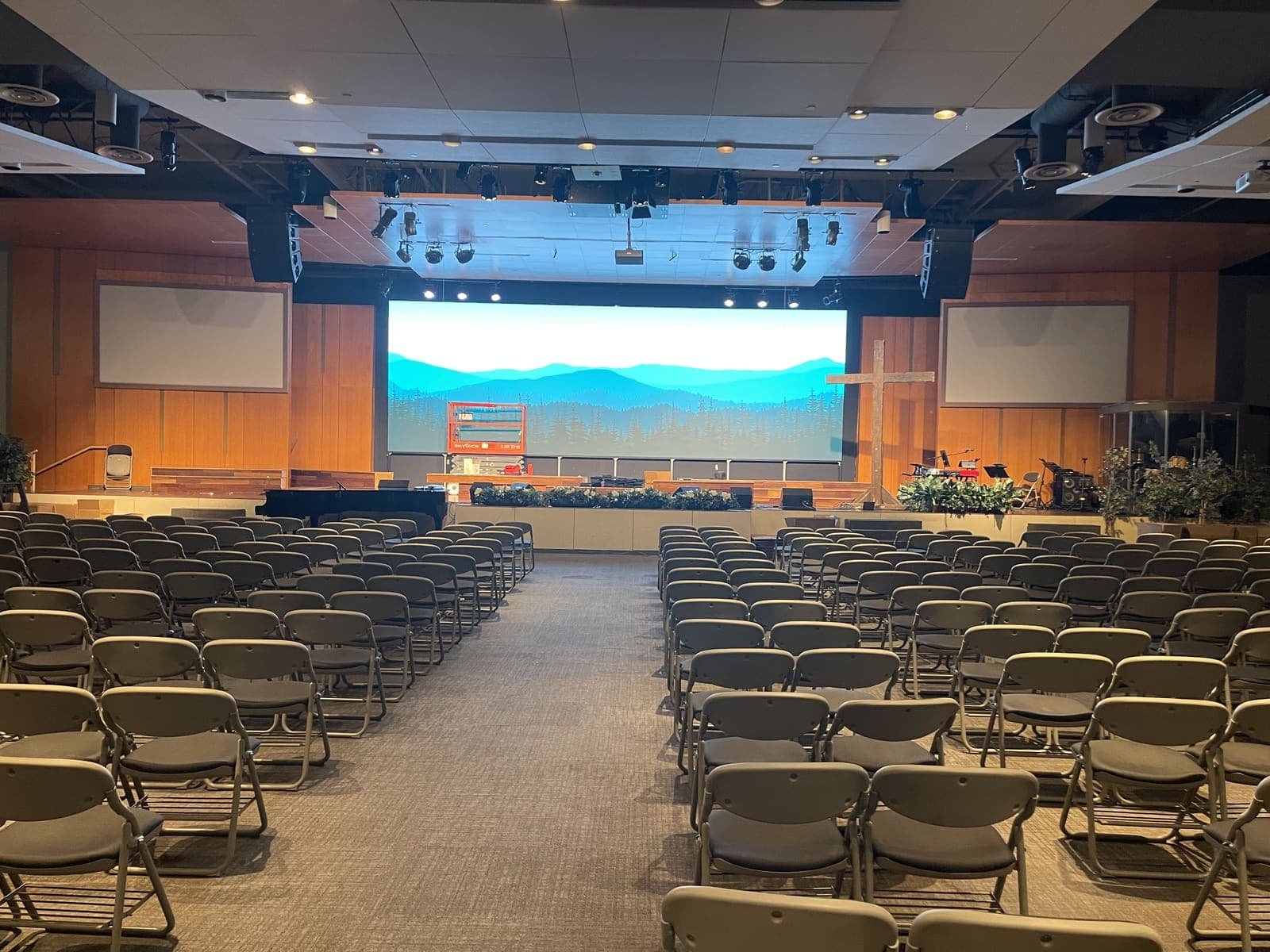 A large hall, one wide wall between two projection screens